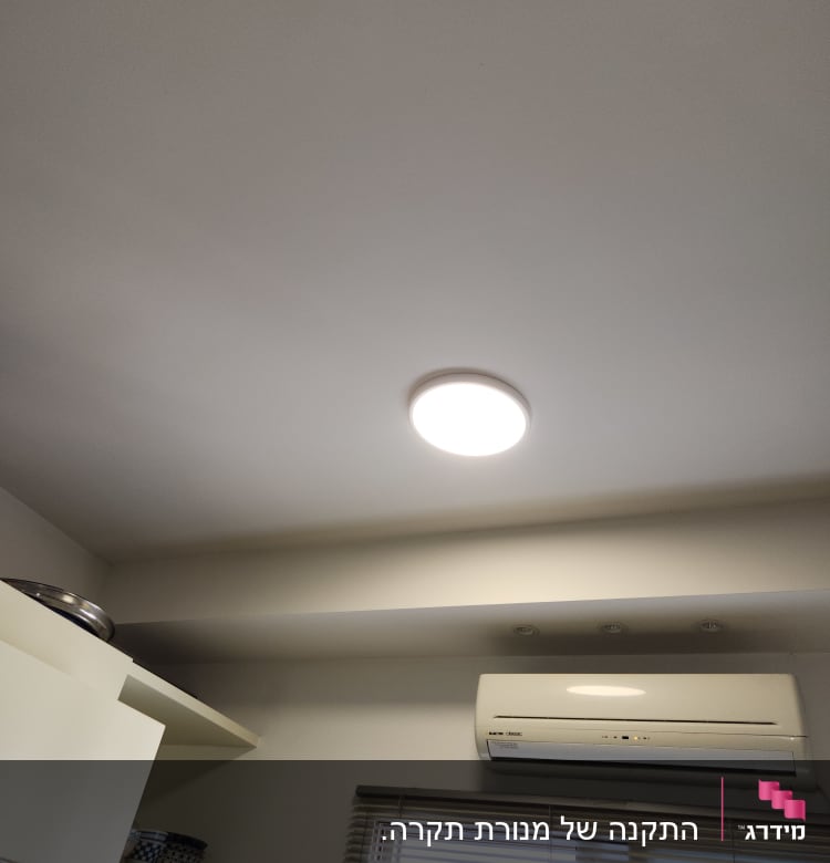 תאורה עגולה בתקרה ליד מזגן